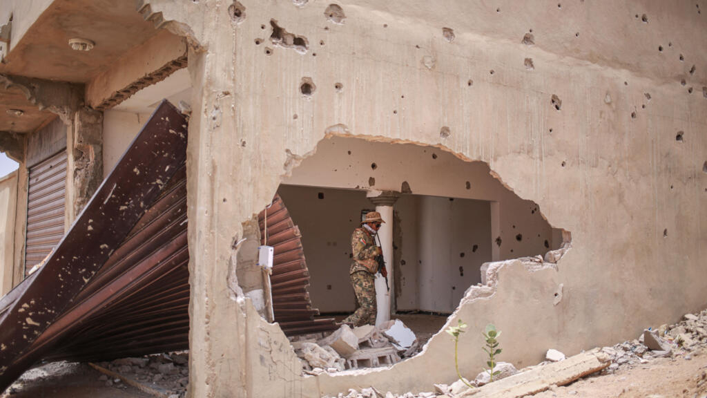 Un soldat du Front national de libération de l'Azawad (FLA) patrouille dans un bâtiment endommagé à Kidal, le 9 mai 2026.