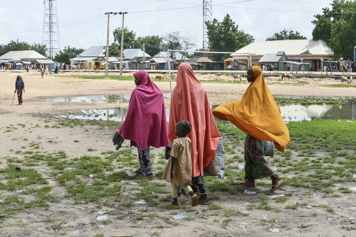 Des survivants et des proches marchent dans un village du nord-est du Nigeria après une attaque attribuée à Boko Haram