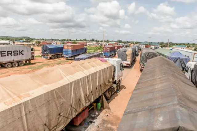 Une longue file de camions bloqués à la frontière entre le Bénin et le Niger, illustrant les conséquences économiques de la fermeture.