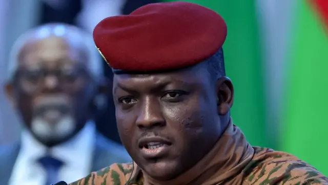 Portrait du capitaine Ibrahim Traoré en tenue militaire beige avec un béret rouge.