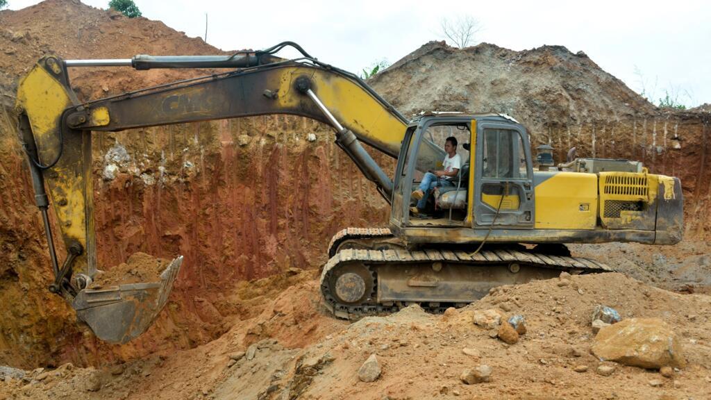 Employé chinois d'une société minière conduisant un bulldozer sur un site aurifère à Betare-Oya, Cameroun